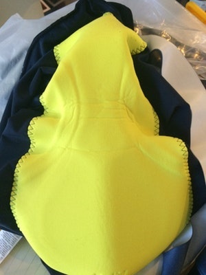 Bright yellow cycling chamois pad on dark fabric.