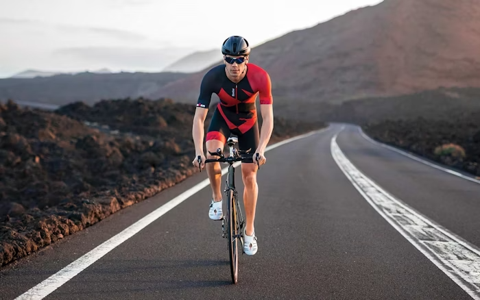 Cyclist Riding on a Mountain Road at Sunrise in Santini Gear